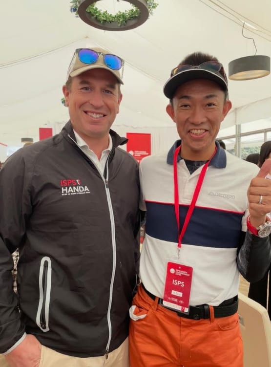 ISPS HANDAの大会会場で、ピーター・フィリップス氏と並んで写るMIWAの代表